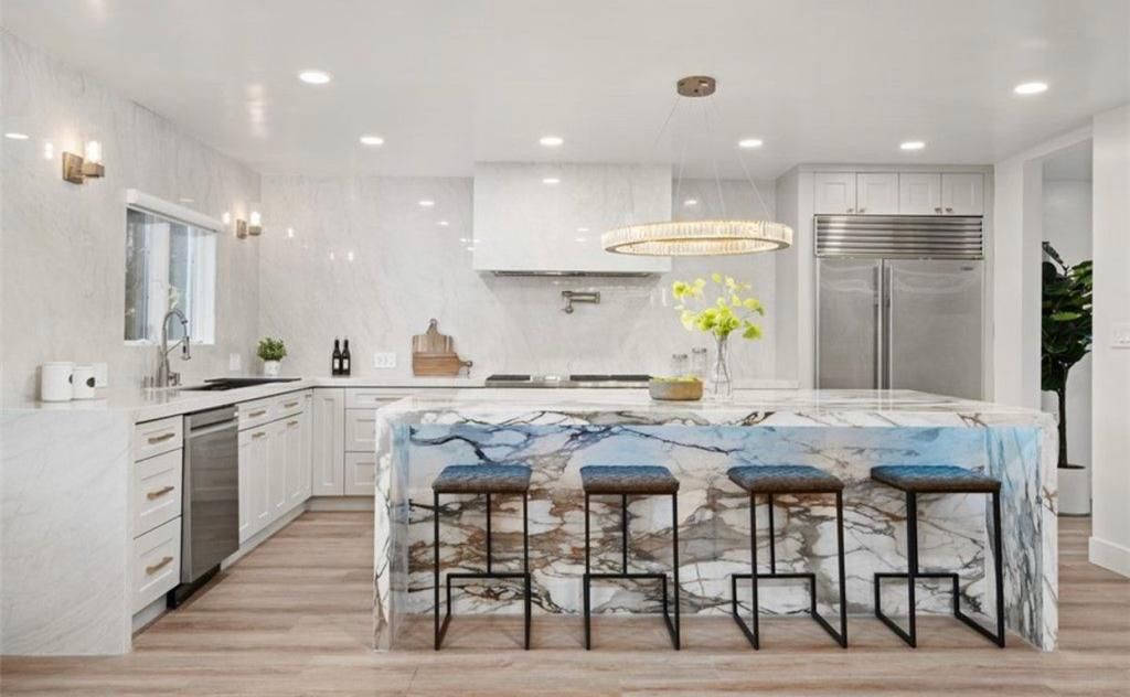 Luxurious kitchen with marble countertops and a large island.